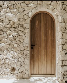 an arched wooden door on a stone wall