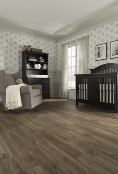 a baby's room with a rocking chair, crib and dresser in it