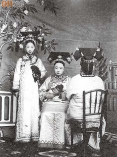 an old black and white photo of three women in traditional chinese dress sitting at a table