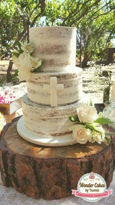 a wedding cake sitting on top of a tree stump