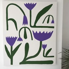 a painting with purple and green flowers in the center on a white wall next to a potted plant