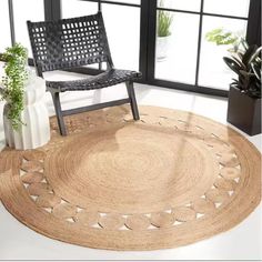 a chair sitting on top of a rug in front of a window next to a potted plant