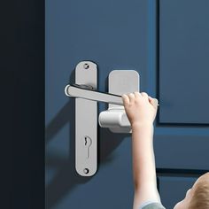 a little boy is holding onto the handle of a door lock and trying to open it