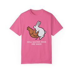 🐰 Get ready to hop into Easter with our delightful garment-dyed t-shirt featuring a whimsical design of a chicken and a bunny pondering the age-old question: "How are Easter eggs made?" 🌷 Crafted from 100% ring-spun cotton, this tee offers unbeatable softness and comfort, perfect for everyday wear. The soft-washed, garment-dyed fabric adds an extra level of coziness to your wardrobe, ensuring you feel comfortable all day long. 🧵 With double-needle stitching throughout, this t-shirt is built to last, maintaining its durability wash after wash. Plus, the lack of side-seams ensures the shirt retains its tubular shape, providing a flattering fit for any body type. 🎨 Make this tee your own by customizing it with your favorite designs, photos, or logos, creating a unique look that reflects y Funny Pink T-shirt For Spring, Spring Cotton T-shirt With Bunny Design, Pink Novelty T-shirt With Funny Print, Easter Pink Cotton T-shirt, Pink Cotton Easter T-shirt, Pink Cotton T-shirt For Easter, Casual Short Sleeve T-shirt For Easter, Easter Letter Print Short Sleeve T-shirt, Easter T-shirt With Letter Print And Short Sleeves