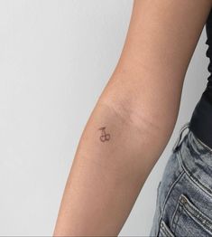 a woman's arm with a small tattoo on the left side of her arm