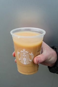 a person holding up a cup of coffee