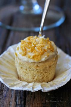 a close up of a cupcake on a paper plate with a fork in it