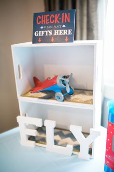 there is a toy airplane on top of a shelf with the word fly in front of it