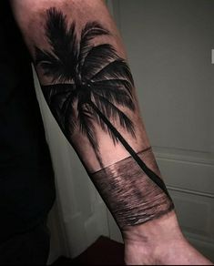 a man's arm with a palm tree tattoo on it