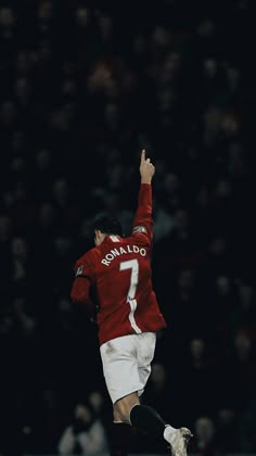 a man in red jersey kicking a soccer ball