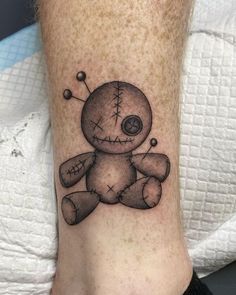 a tattoo on the leg of a person with a teddy bear