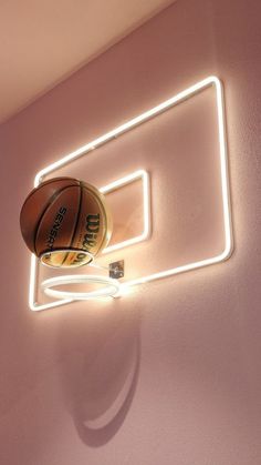 a basketball is hanging on the wall next to a neon light