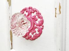 a pink door handle on a white door