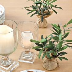 a table topped with plates and vases filled with plants