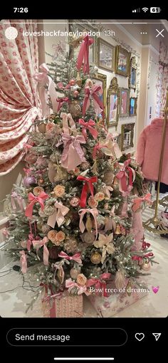 a small christmas tree with pink bows on it