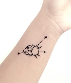 a small tattoo on the wrist of a woman with stars and an arrow in it