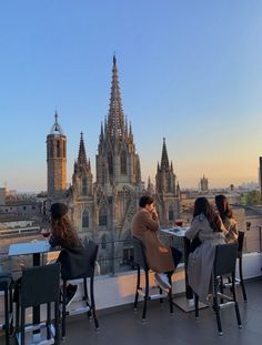 three people sitting at a table on top of a roof