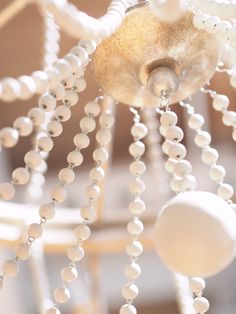 a white chandelier with beads hanging from it