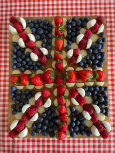 an arrangement of strawberries, blueberries, and raspberries arranged in the shape of a cross