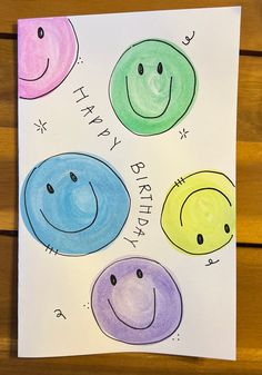 a card with four smiley faces on it and the words happy birthday written in different colors