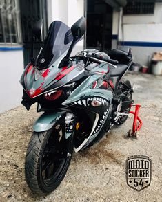 a motorcycle parked in front of a building with graffiti painted on it's side