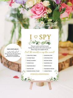 a table with a sign that says i love spy on it and flowers in the background