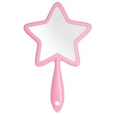 a pink star shaped mirror hanging on a wall next to a toothbrush and spoon