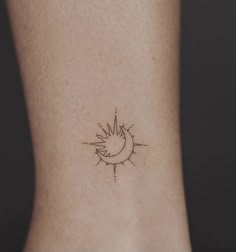 a small sun and moon tattoo on the back of a woman's left leg