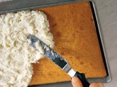 someone using a knife to cut up some food on a sheet of baking parchment paper