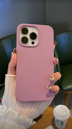 a woman holding up her pink phone case