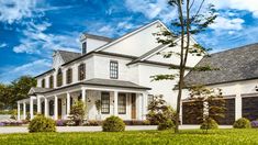 a large white house sitting on top of a lush green field