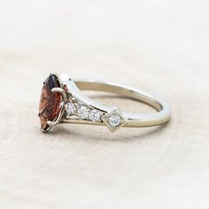 a ring with an orange and white stone in it