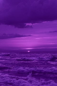 the sun is setting over the ocean with purple hues and white foamy waves