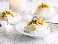 there are two desserts on the table with white doily and candles in the background