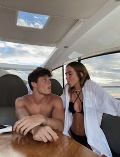 a man and woman are sitting in the back of a boat looking at each other