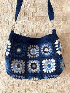 a crocheted purse hanging on a brick wall