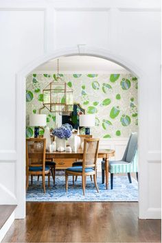 a dining room table and chairs in front of an archway