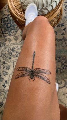 a woman's legs with a tattoo on her leg and a dragonfly design