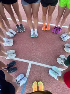 a group of people standing in a circle on top of a tennis court next to each other