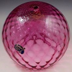 a pink glass ball sitting on top of a table