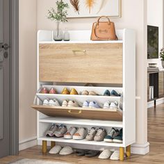 a white shoe rack filled with lots of pairs of shoes next to a painting on the wall