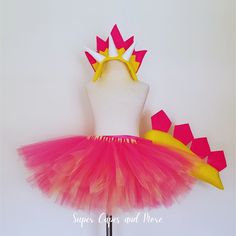 a pink and yellow tutu skirt with bows on it, next to a white mannequin