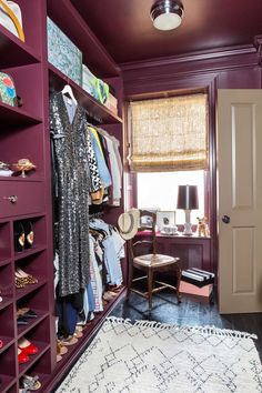 a walk in closet with purple walls and shelving