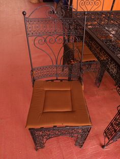 an iron bench and chair in a room