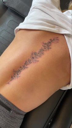 a woman's lower back tattoo with flowers on it