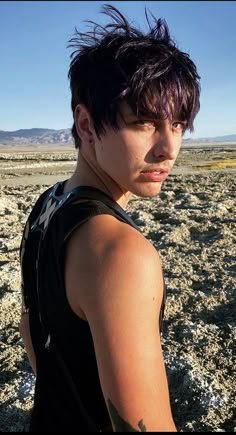 a young man standing in the middle of an open field