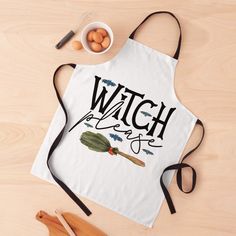 a white apron with the words witch biscuit on it next to eggs and utensils