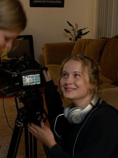 a woman with headphones on is filming another woman in front of a television camera