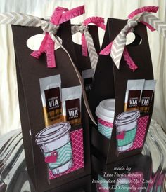 two brown paper bags with pink bows on them and some coffee cups in the bag