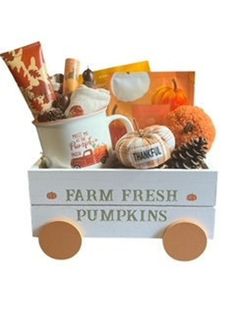 a wooden wagon filled with farm fresh pumpkins and other fall foods, including apples